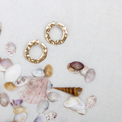 Fototapeta na wymiar Minimal fashion composition with golden earrings in seashell on table. Flat lay, top view a jewelry concept on mosaic tile background.