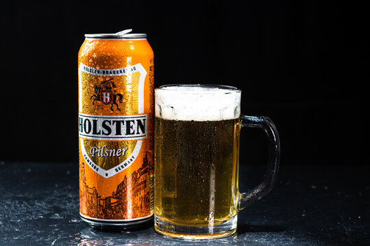 Can of Holsten beer and beer glass on dark background. Illustrative editorial photo shot in Bucharest, Romania, 2021