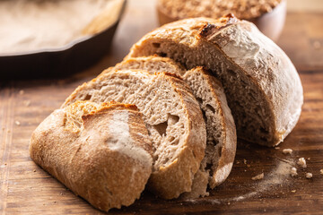 Savoury and crunchy slices of yeast bread with whole wheat grains in the background