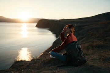 pretty woman tourist with backpack admiring the landscape sunset vacation