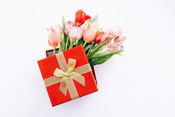 Gift box with bouquet of beautiful tulips on white background, top view