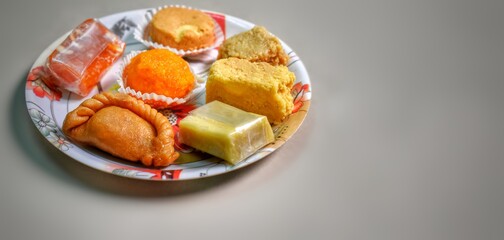 Indian sweets in a plate includes kaju katli, morichoor / Bundi Laddu, Gujiya or Karanji for diwali celebration
