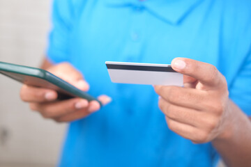 Man hand holding credit card and using smart phone shopping online 