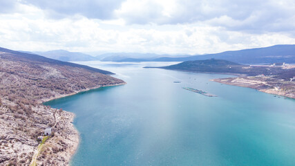 Aerial drone view of lake. Flying above water. Hydro accumulation lake. Artificial lake near hydroelectric power plant in mountains. Water reservoir for electricity production.