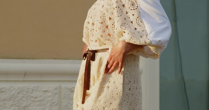 Giovane ragazza con vestito bianco fa da modella in un parco verde