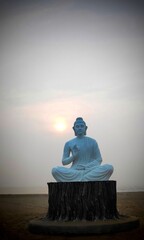 Buddha in a meditation pose, under protection of the king of nag - Mukalinda. Figure isolated on a sun and beach background.