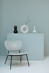 A blue chair against the background of a minimalistic composition and a plain wall. Stylish interior design