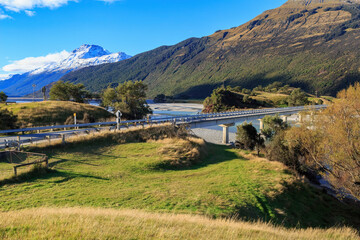 A bridge over the Dart River in the South Island of New Zealand, flowing through a mountainous and beautiful landscape 