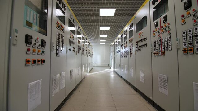 Motion between closed cabinets with switchboards and screens showing data at electrical distribution substation closeup