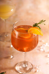 Orange christmas alcoholic beverage aperol spritz and lemonade with oranges, tangerines and rosemary in many glasses