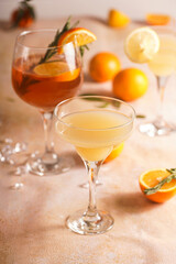 Orange christmas alcoholic beverage aperol spritz and lemonade with oranges, tangerines and rosemary in many glasses