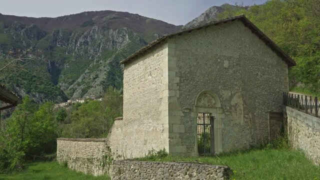 Ancient country church, in the background the medieval village of Anversa degli Abruzzi. Anversa degli Abruzzi, province of l'Aquila, Abruzzo, Italy, Europe