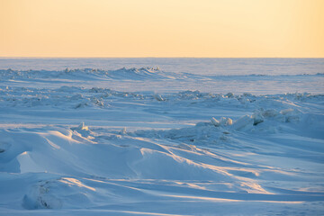 Winter arctic landscape. View of snow and ice at sunset. Ice hummocks on the frozen sea in the Arctic. Cold frosty winter weather. Harsh polar climate. Travel and hikes to the far north to the Arctic.