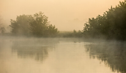 Obraz na płótnie Canvas misty sunset sunrise on river with trees