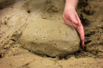 homemade bread dough made and formed by hand a large pot. Woman's hands kneading the bread dough.