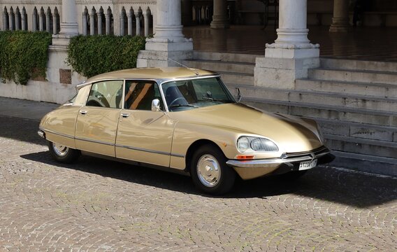 Udine, Italy. May 8, 2021. Shiny gold colored Citroen DS parked In the historical center of the city. It is the famous vintage car of the french automaker produced from Fifties till Seventies