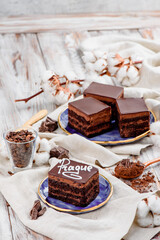 Traditional Prague chocolate cake on a blue plate on a light wooden background. Beautiful composition. Space for text. High quality photo