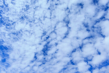 Fototapeta na wymiar Wallpaper with cirrus and stratocumulus clouds against blue spring sky