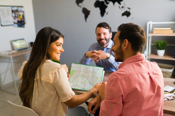 Fototapeta premium Happy couple looking at a tourist country map