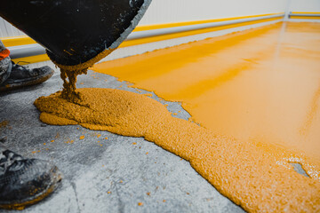 Worker applying epoxy and polyurethane flooring system
