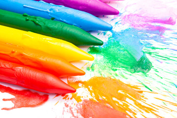 close-up rainbow colored school crayons with burst ink. Concept art.