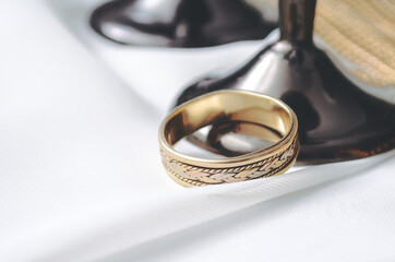 Gold wedding ring with glasses on the table
