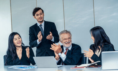 Senior caucasian manager working in office with assistance of young Asian business people and...