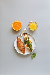 Creative minimal layot from breakfast table with croissants sandwich, asparagus and egg. Top view, copy space