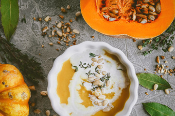 Pumpkin soup, On a gray background with pumpkins, Autumn atmosphere, Top view, Selective focus