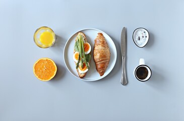 Creative minimal layot from breakfast table with croissants sandwich, asparagus and egg. Top view, copy space