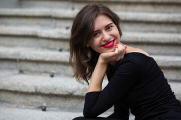 Street portrait of a joyful woman with red lips and short hair
