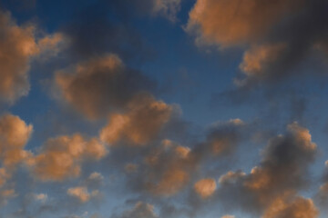 Heavenly landscape background with the texture of clouds at sunset. Beautiful morning sky in blue and orange colors. 