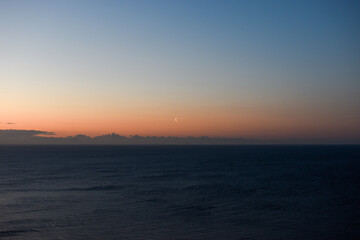 Naklejka na ściany i meble sunrise, dawn over the sea with the moon in Ireland