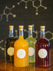 Glass bottles of liquers with colorful content. Dark bar wall