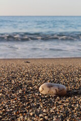 Strand mit Stein im Vordergrund, Meer