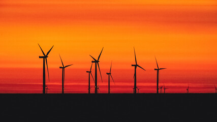 Offshore Wind Turbines set against a sunrise red sky