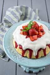 Traditional German cheesecake with strawberry fruits served as close-up in a cake dish on a wooden
