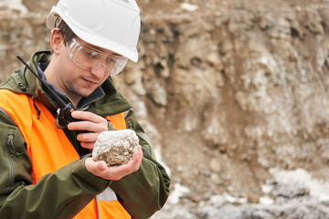 geologist examines a mineral sample - obrazy, fototapety, plakaty