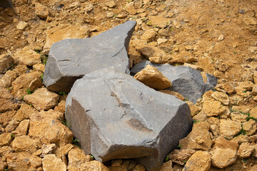 large gray stones lie on yellow clay 