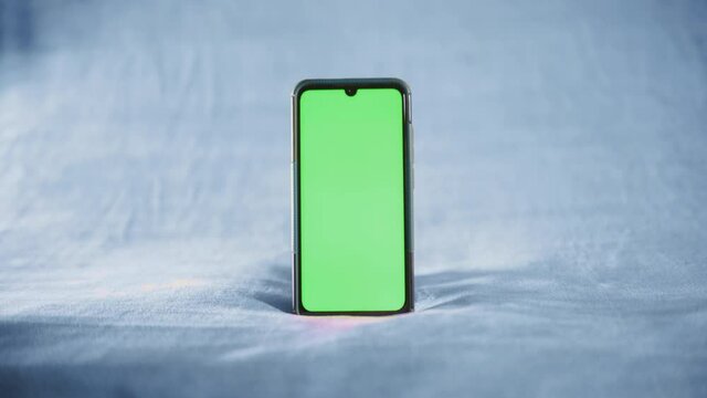 smartphone avec fond vert sur fond isol&eacute; bleu