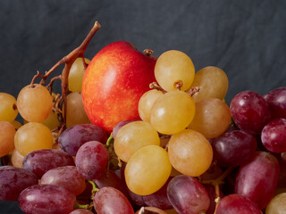 fresh ripe red grapes on a wood texture surface. Ancient style, beautiful background with a branch of blue grapes. Red grape. Dark grapes