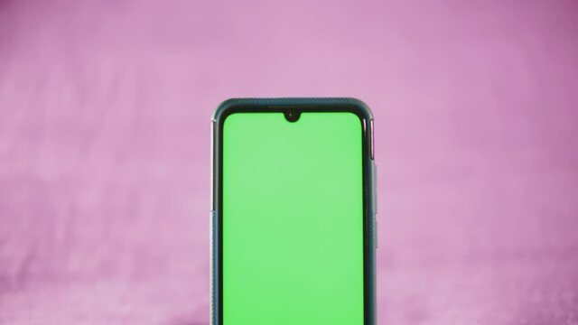 smartphone avec fond vert sur fond isol&eacute; rose