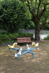 初夏の日差しの下、新緑と公園の遊具