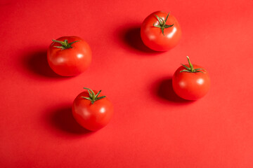 Juicy tomatoes on a bright red background. Fresh vegetables on a branch. Kitchen. background for restaurant.