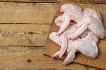 Raw chicken wings on a wooden background. Fresh chicken meat. Healthy diet.