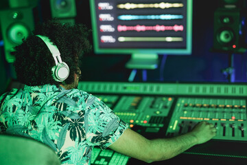 African american man mixing music inside recording studio - Music industry and technology concept