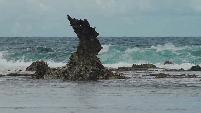 Ocean waves breaking on a sharp rock