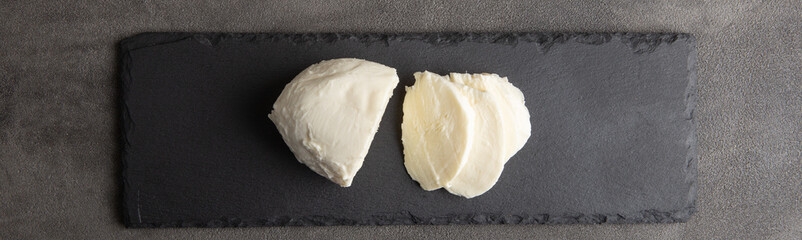 Fresh tasty mozzarella close-up. Concrete grey background.