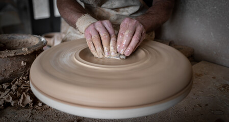 Potter hands working carefully on pottery, closeup view