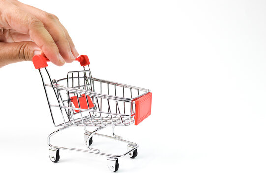 Hand holding shopping cart isolated on a white background. Conceptual image